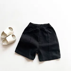 Detalle de pantalones cortos negros de algodón para niños con cintura elástica y bolsillos