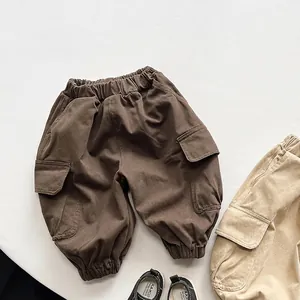 Detail view of cargo pants with elastic waist and flap pockets in brown and khaki