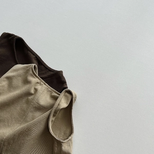 Detailed close-up of ribbed knit vests in dark brown and beige with fine stitching