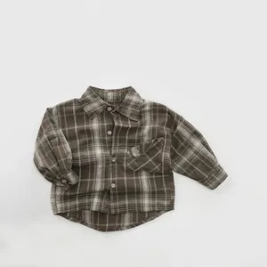 Close-up detail of children's vintage brown plaid shirt featuring a chest pocket and buttons