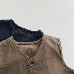 Detailed close-up of V-neck cotton vest featuring texture fabric and a single button