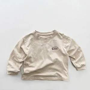 Detail von weichem beige Baumwoll-Kinder-T-Shirt mit HAPPY DAY Druck und Rippbündchen
