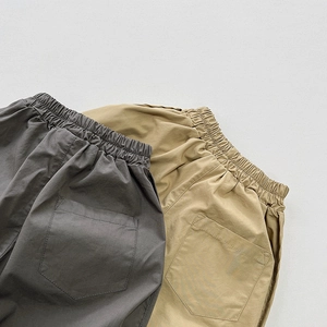 Detail of kids cotton pants featuring elastic waist and large back patch pockets