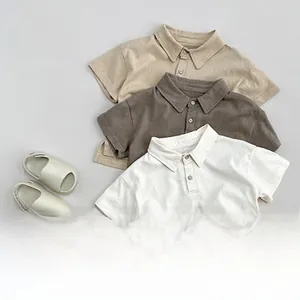 Flat lay of Korean style cotton toddler polo shirts in khaki and cream with matching sandals