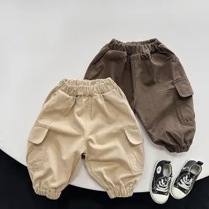 Detailed flat lay of children's cargo pants in khaki and brown with side pockets