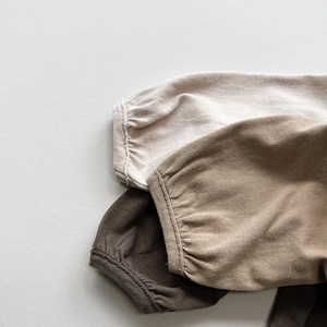 Close-up of ribbed cuffs on children's cotton long sleeve shirts in neutral tones