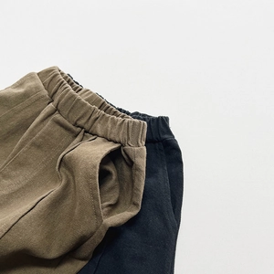 Detalle de la cintura elástica y bolsillos laterales en pantalones de sarga