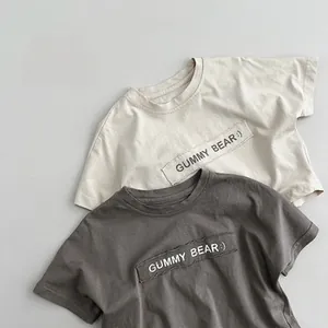 Detail of kids cotton t-shirts featuring Gummy Bear lettering and ribbed crew neck style