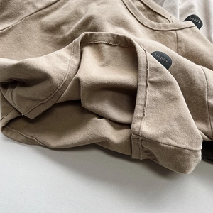 Close-up of a high-quality cotton T-shirt featuring a thick crew neck and Happy fabric label