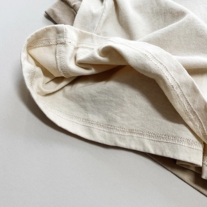 Detail der Doppelnaht und feinen Baumwolltextur am Kinder-T-Shirt aus Leinen-Baumwolle