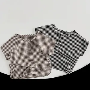 Close-up of kids' short sleeve cotton shirts in brown and black gingham plaid patterns