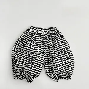 Detail view of girls linen casual trousers with black and white wavy pattern and elastic cuffs