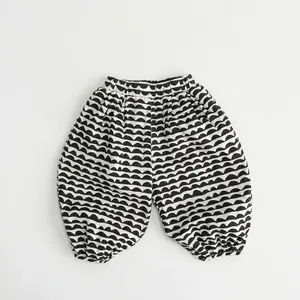 Detail of children's linen-blend harem pants featuring a black and white wavy pattern
