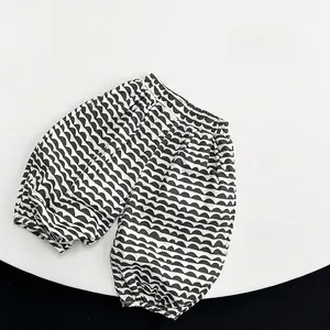 Detail of children's wide elastic waistband and linen fabric texture on wavy print pants