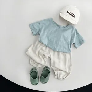 Sommer Kinderbekleidungsset mit hellblauem T-Shirt, cremefarbener Hose und weißer Mütze