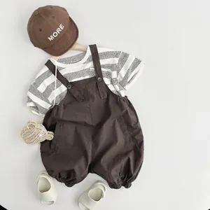 Ensemble t-shirt enfant rayé noir et blanc avec une salopette marron en deux pièces