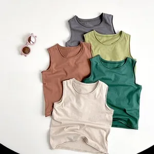 Flat lay of five cotton sleeveless vests for kids in earth tones with round neck design