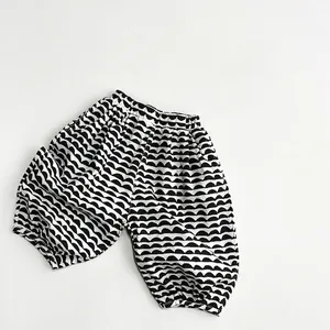 Detailed view of girls' linen pants with black and white wavy patterns and elastic waist