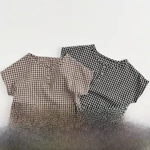 Detail of kids short sleeve plaid cotton shirts with round neck and button closure
