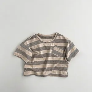 Détail d'un t-shirt rayé doux pour enfant avec col rond et petite poche de poitrine
