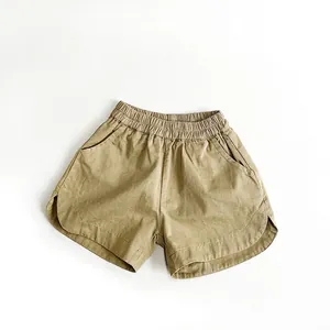 Dettaglio dei pantaloncini in cotone kaki per bambini con vita elastica e tasche laterali