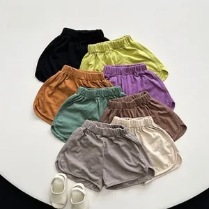 Flat lay of colorful children's cotton shorts with elastic waistband in eight vibrant shades