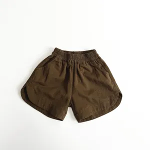 Dettaglio dei pantaloncini in cotone marrone con vita elastica e orli arrotondati