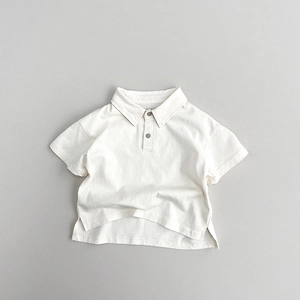 Detail of cream cotton kids Polo shirt featuring ribbed collar and side split hem design