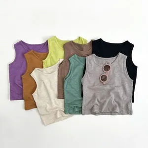 Flat lay of colorful children's cotton tank tops in five earthy tones with summer sunglasses