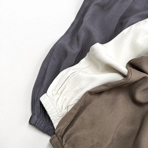 Nahaufnahme der elastischen Bündchen an atmungsaktiven Kinderhosen in Grau, Beige und Braun