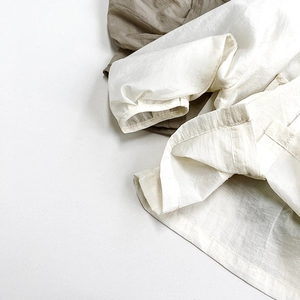 Vue détaillée du tissu respirant en lin blanc et vert olive pour vestes d'enfants
