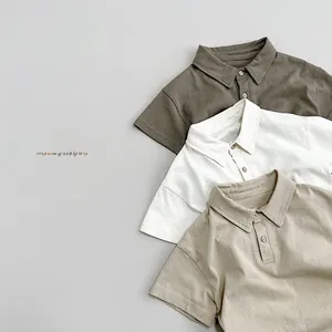 Detail view of cotton kids polo shirts showing collared necklines in earth tone colors
