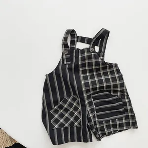 Detail of baby linen cotton bib shorts featuring asymmetrical stripes and grid patterns