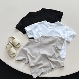 Detail view of cotton kids t-shirts in black white and oat with double-stitched neckline