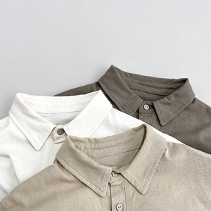 Close-up of stacked polo shirts showing cotton knit texture and detailed button collars