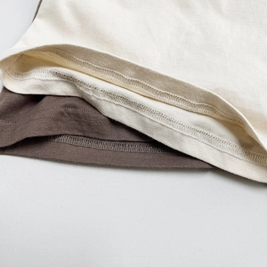 Détail de la double couture et de la finition de l'ourlet sur t-shirts enfant