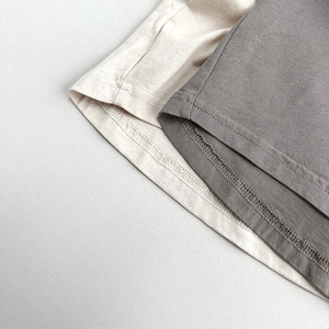 Détail de la couture à double aiguille sur l'ourlet de t-shirts en coton pour enfants