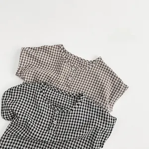 Flat lay of brown and black gingham cotton shirts with round collars and buttons