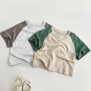 Detailed close-up of breathable slub cotton fabric on kids colorblock raglan sleeve tees