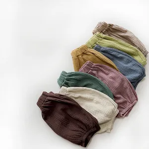 Close-up of baby cotton gauze bloomers in multiple Morandi colors on white background