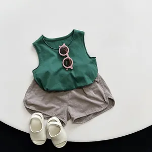 Flat lay of green cotton vest and gray shorts summer outfit set with breathable texture
