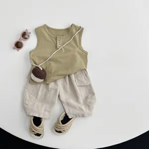 Flat lay of boys cotton linen summer outfit with green vest and beige cargo shorts