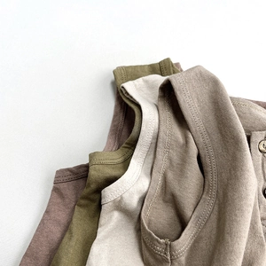 Close-up of knit cotton kids vests with natural wood buttons in various neutral colors