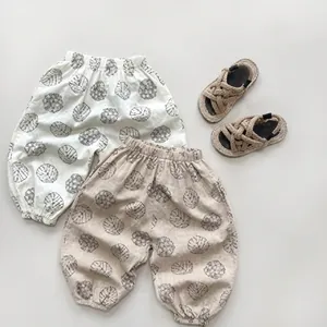 Close-up of cotton children's summer pants with black leaf prints and elastic cuffs
