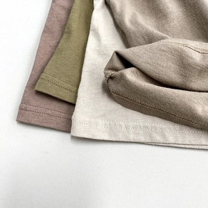 Close-up of cotton tank tops showing fine stitching and earth tone fabric texture