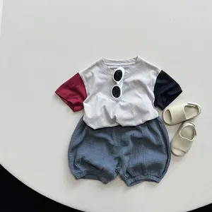 Flat lay of a children's color-block cotton T-shirt and blue bloomers summer outfit