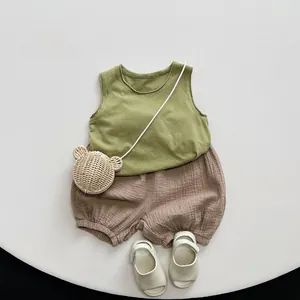 Flat lay of cotton olive green tank top and brown bloomers with bear shaped woven bag