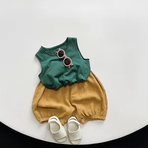 Flat lay of cotton linen summer set with dark green vest and yellow bubble shorts