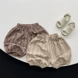 Detail of baby striped bloomers with elastic waist in coffee and beige colors