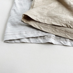 Detailed macro view of the breathable slub texture fabric and neat double-needle hem stitching